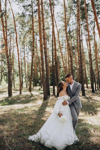 Jong koppel met huwelijksfotosessie in het bos op hun trouwdag