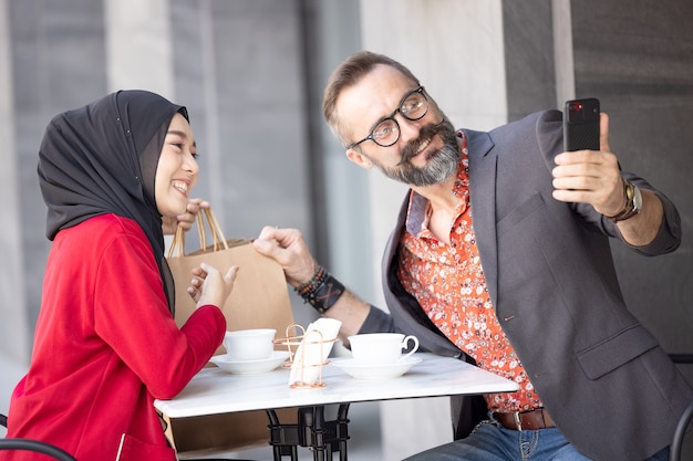 Jong koppel met romantisch in het restaurant zitten fotograferen