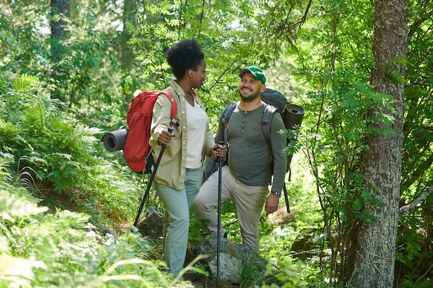 Jong koppel met rugzakken genieten van hun reis samen in het bos