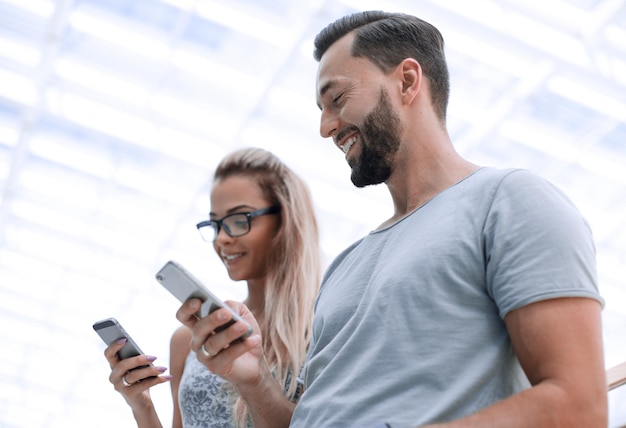 Jong koppel met smartphone op een lichte achtergrond