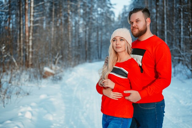 Jong koppel omarmen in Winter Forest. Winter vakanties