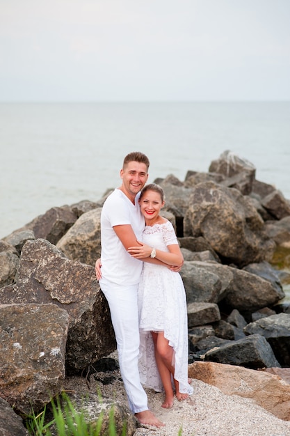 Jong koppel op de rotsen in de zee