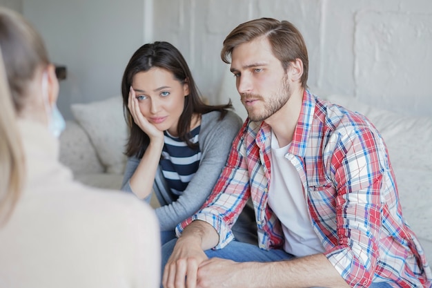 Jong koppel praten over hun probleem met psycholoog in functie.