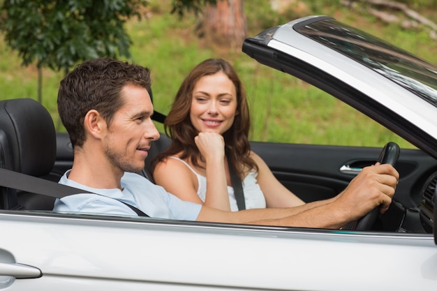 Jong koppel rijden in een zilveren cabriolet