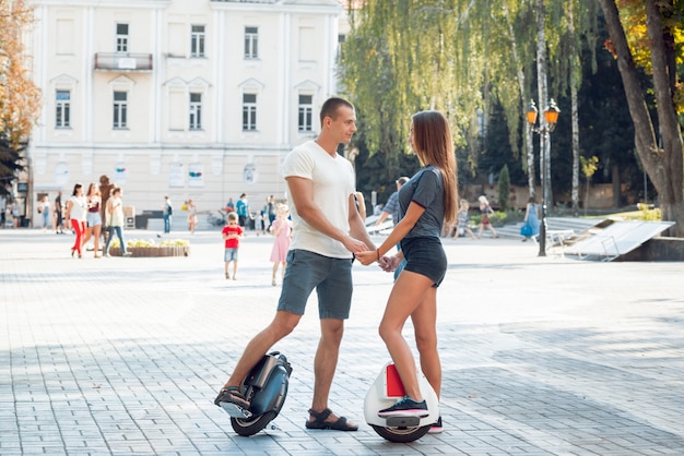 Jong koppel rijden op monowheel in het park