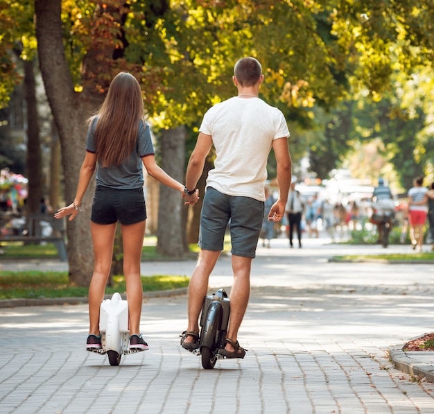 Jong koppel rijden op monowheel in het park