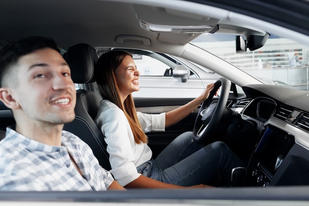 Jong koppel samen kiezen voor hun nieuwe auto in een autowinkel