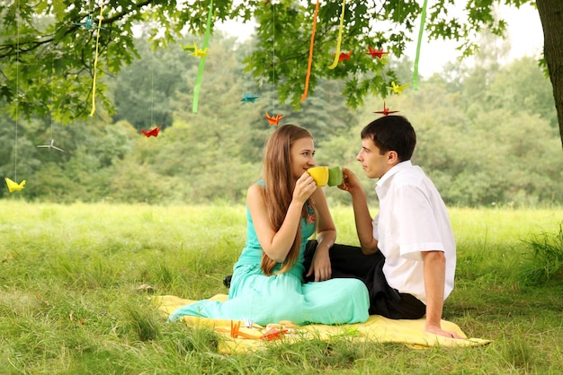 Jong koppel thee drinken in het park