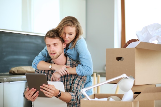 Jong koppel verhuizen naar nieuw huisZitten en ontspannen na het uitpakkenIets kijken op laptop Jong koppel