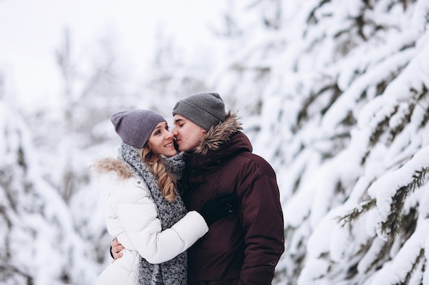 Jong koppel verliefd buiten besneeuwde winter