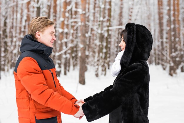 Jong koppel verliefd hand in hand buiten in de winter natuur.