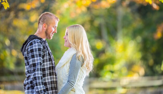 Jong koppel verliefd knuffelen en zoenen in herfst park.