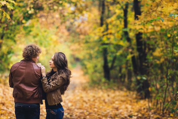 Jong koppel verliefd knuffelen in herfst park.