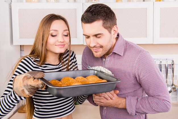 Foto jong koppel verliefd ruiken gebakken taarten in de keuken