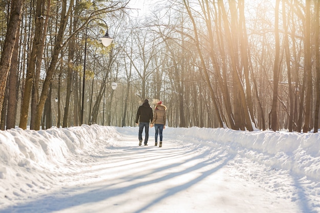 Jong koppel verliefd wandelen in het besneeuwde bos.