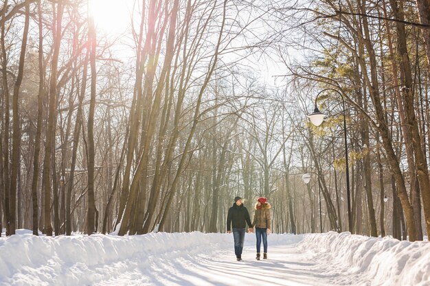 Jong koppel verliefd wandelen in het besneeuwde bos.