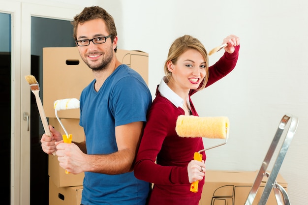 Jong koppel verplaatsen in een huis of appartement, ze schilderen en doen renovatiewerkzaamheden