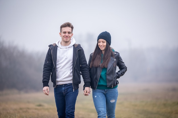 Foto jong koppel wandelen in de natuur op een mistige winterdag