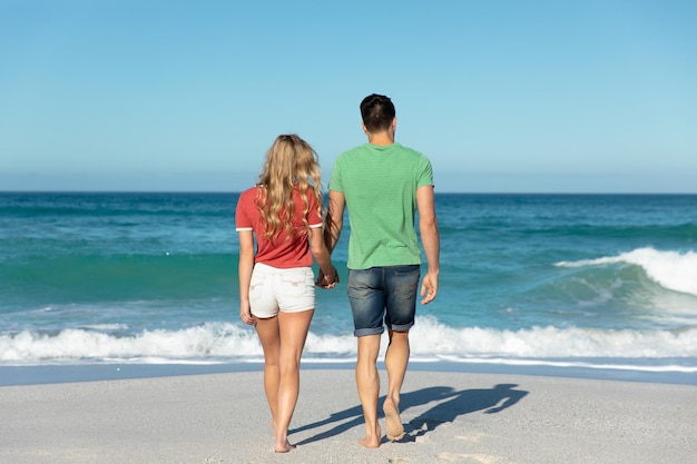 Jong koppel wandelen op het strand