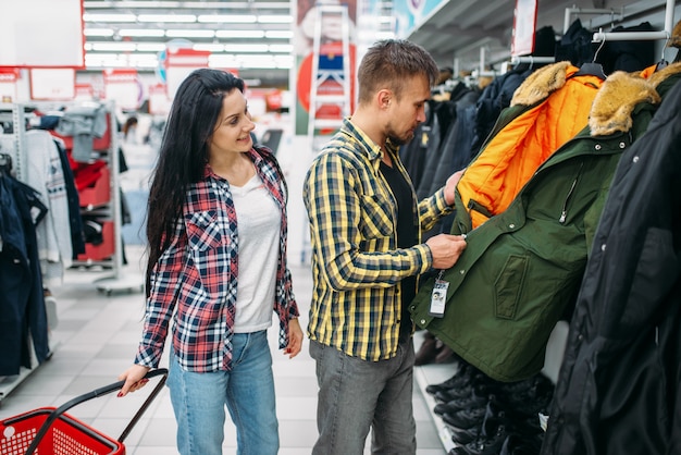 Jong koppel warme kleren kiezen in de supermarkt