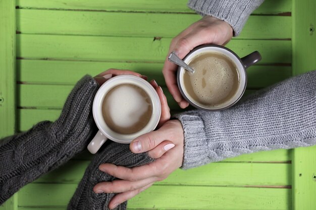 Jong koppel warme koffie drinken aan een houten tafel op een date