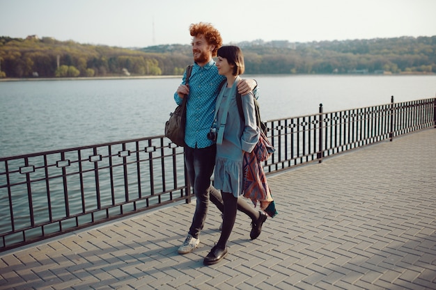 Foto jong koppel zorgeloos wandelen in het park in de buurt van het meer