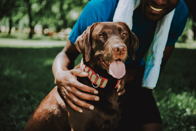 Jong Lachend African American Man knuffelen hond.