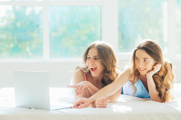 jong lesbisch koppel met laptop op bed