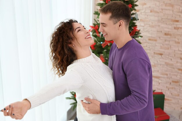 Jong liefdevol paar dat thuis danst op eerste kerstdag