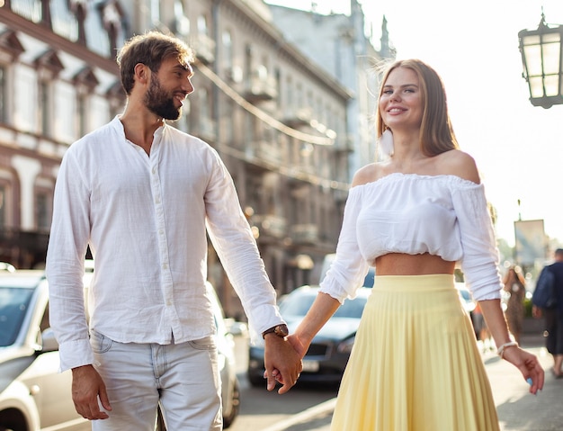 Foto jong, liefhebbend, vrolijk echtpaar wandelt door de stad.