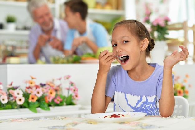 Jong meisje aan het eten in de keuken