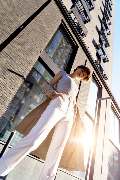Jong meisje adverteert trendy kleding hand in zak gebouw achtergrond copyspace
