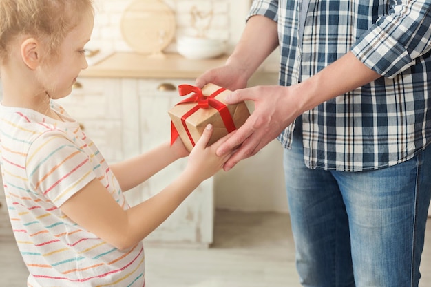 Jong meisje cadeau ontvangen van haar vader. Papa verrast zijn dochtertje met cadeau, kopieer ruimte