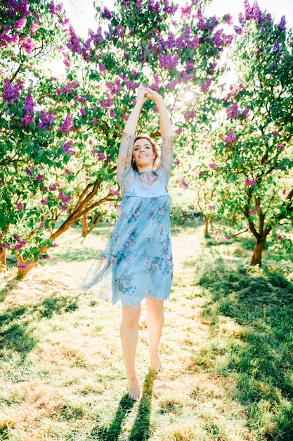 Jong meisje dansen in bloeiende tuin op zomerdag