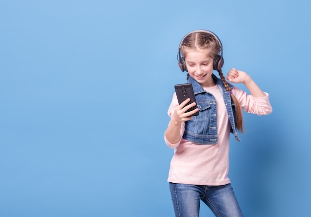 Jong meisje dat aan muziek met hoofdtelefoons luistert