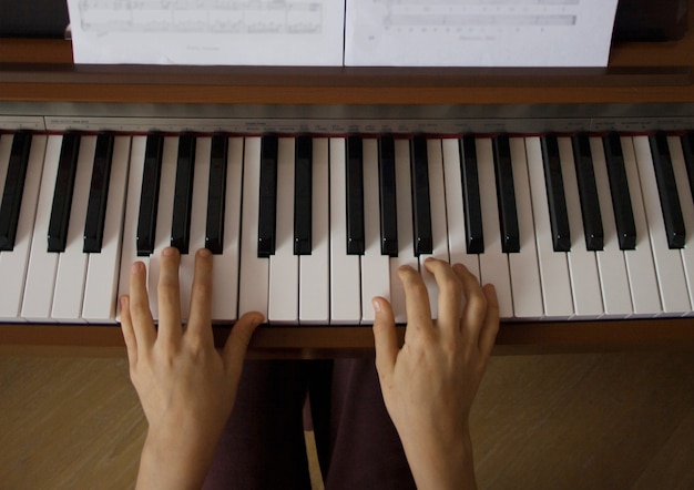 Jong meisje dat digitale piano speelt. Bovenaanzicht