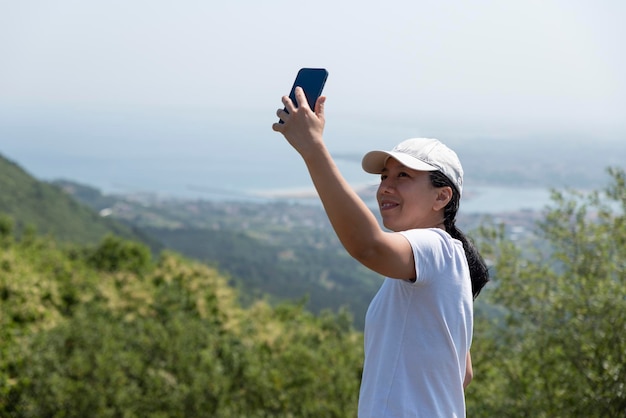 Jong meisje dat een selfie maakt in de bergen