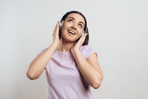 Jong meisje dat in hoofdtelefoons aan moderne muziek luistert