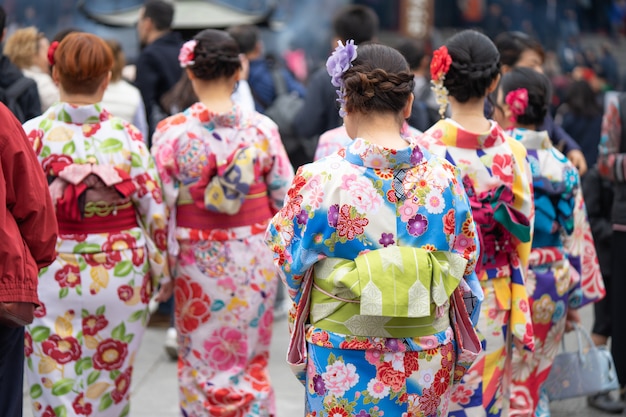 Jong meisje dat japanse kimono draagt die zich voor sensoji-tempel in tokyo, japan bevindt.