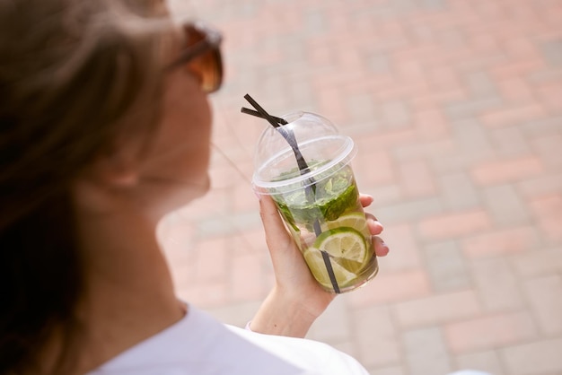 Jong meisje dat koele matchacocktail drinkt bij zonnig weer