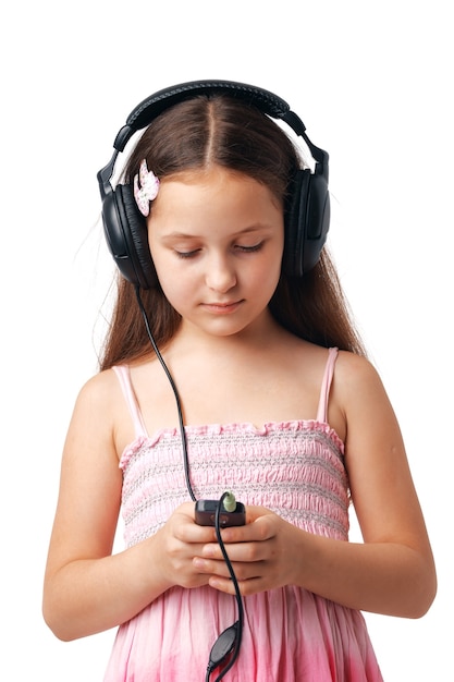 Jong meisje dat met hoofdtelefoons iets in haar mobiel of speler bekijkt