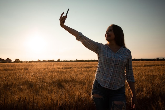 Jong meisje dat selfie neemt in het zomertarweveld