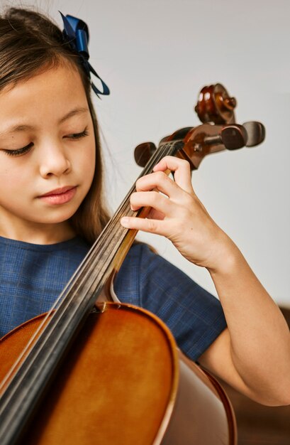 Jong meisje dat thuis leert cello te spelen