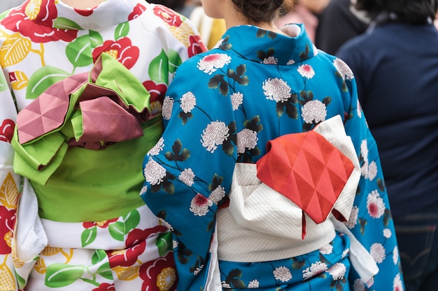 Jong meisje die Japanse kimono dragen die zich voor Sensoji-Tempel in Tokyo bevinden,