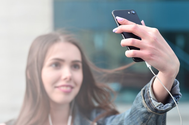 Jong meisje die selfie op de achtergrond van een bureaugebouw doen