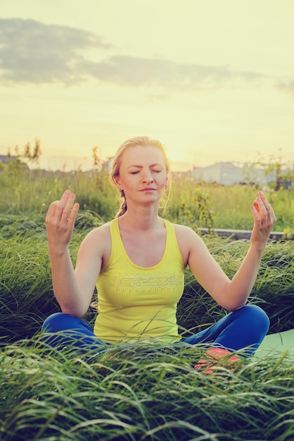 Foto jong meisje doet yoga in de achtertuin