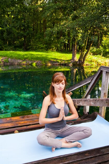 Jong meisje doet yoga lotus pose in het park