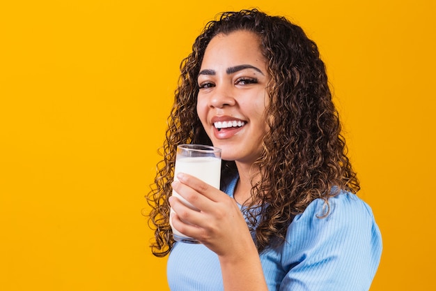 Jong meisje drinken van een glas melk op de achtergrond met ruimte voor tekst.