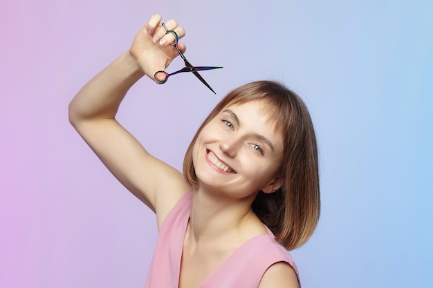 Jong meisje houdt een schaar in haar hand en staat op het punt een knipbeurt te krijgen