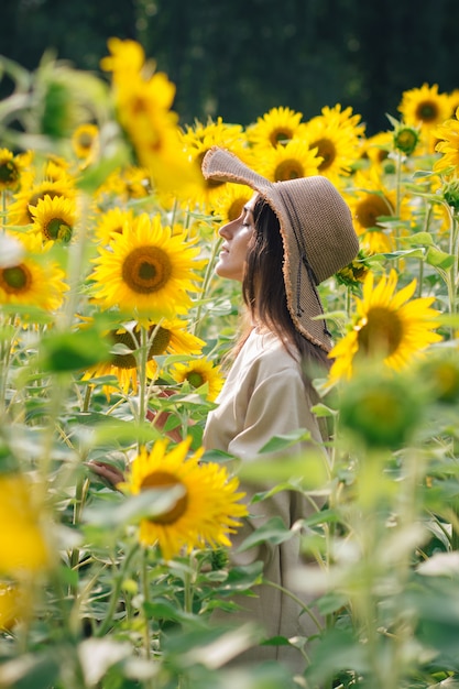 Jong meisje in een hoed op een veld met zonnebloemen